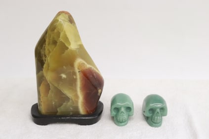 2 aventurine carved skulls, and a jade like boulder
