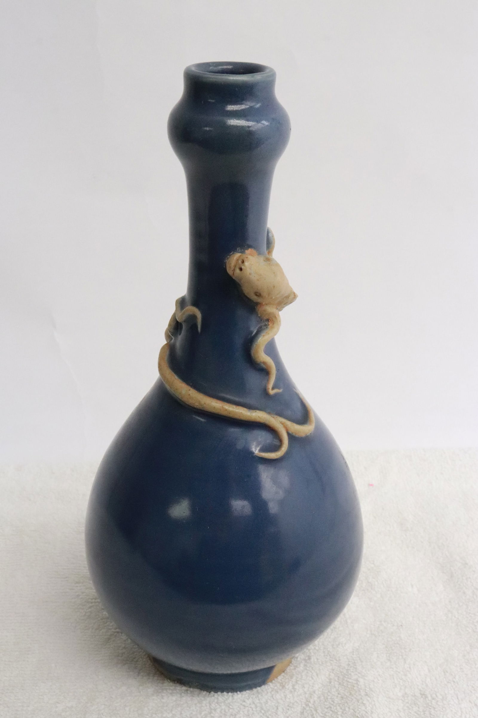 A blue glazed porcelain vase: A blue glazed porcelain vase with qilin motif decoration in high relief, 8.85"x4.2"dia