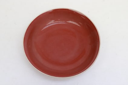 A red glazed porcelain plate