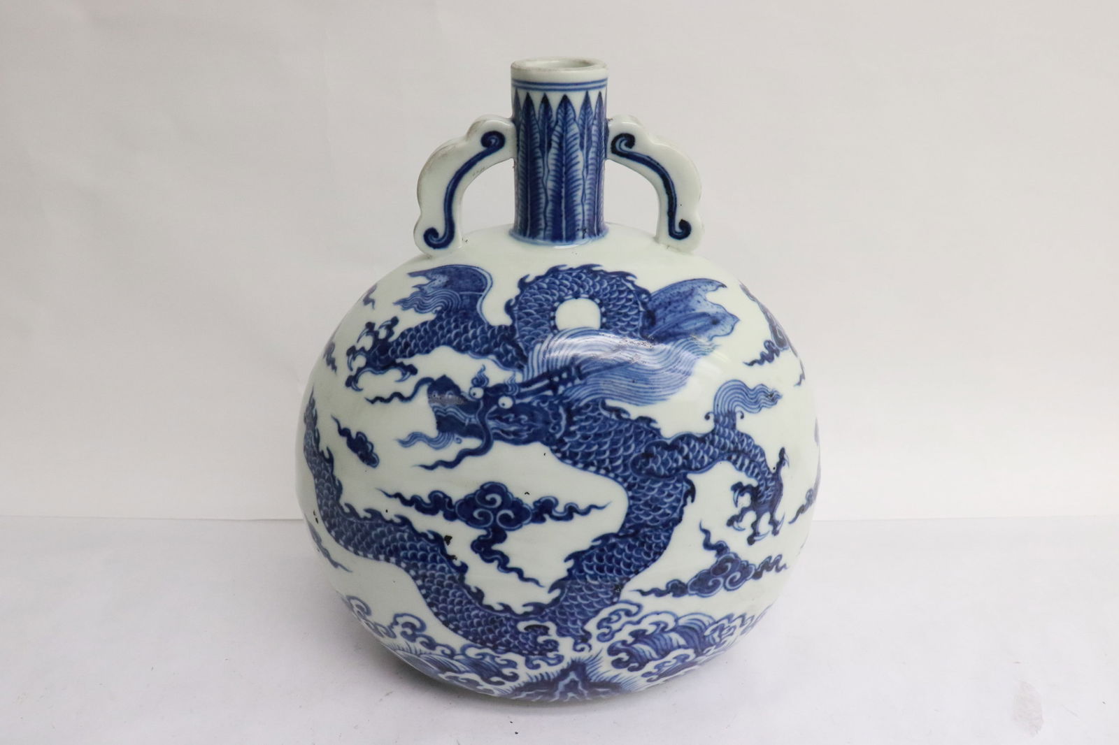 An important Chinese 18th c. blue and white moon flask: An important Chinese 18th century blue and white porcelain moon flask painted with 5 claw dragons on both side, 雍正青花抱月瓶, 10.3"x9"x6.35"