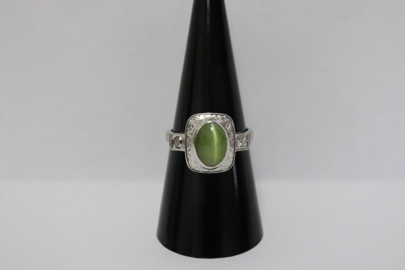 A platinum cat eye stone diamond ring w/ GIA certificate: A platinum ring, center a brilliant natural cat eye stone (貓眼石) wt approx. 2.25ct (by formula), accented with 2 side diamonds, wt. 5.4gm, size 7