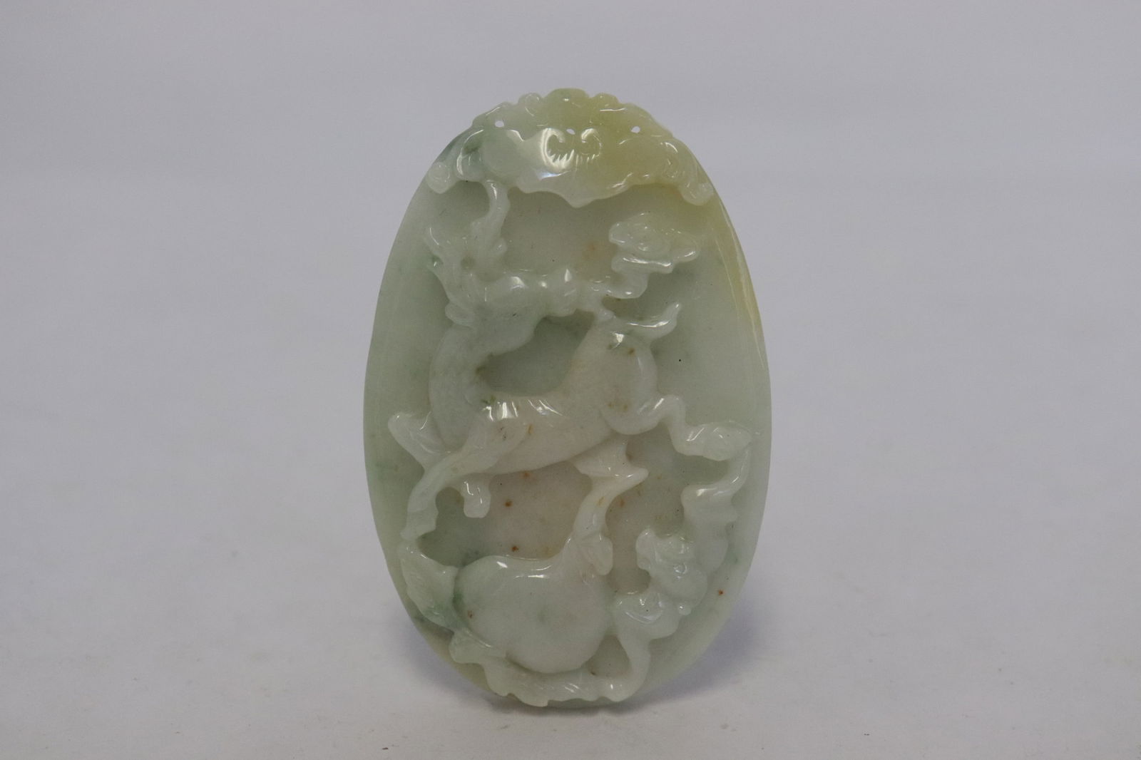 Chinese jadeite carved oval plaque: Chinese jadeite carved oval plaque depicting deer motif decoration in relief, 2.9"x1.85"x0.35"