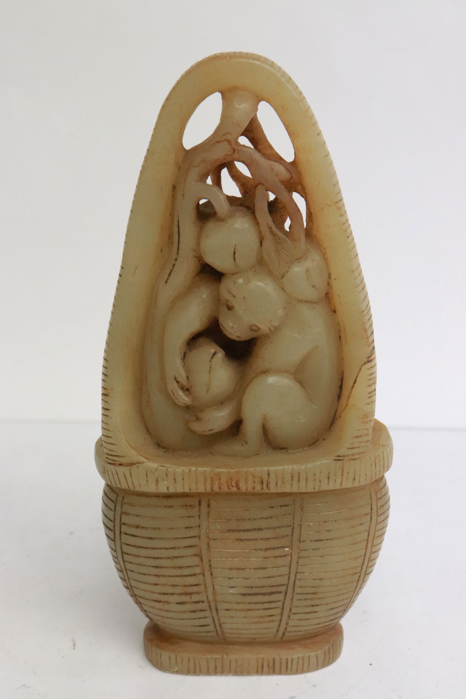 A white jade carving: A white jade carving depicting flower vase with monkey and fruit, 7.2"x3.5"x1.8"