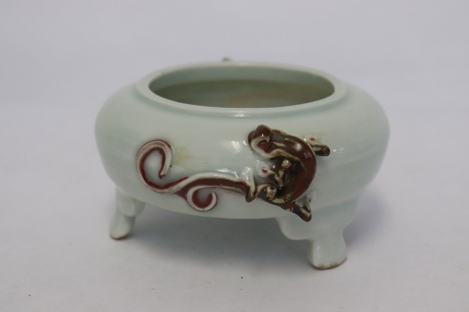 A red on celadon porcelain water dripper: A red on celadon porcelain water dripper with qilin motif decoration in relief, 1.85"x4.15"x3.65"