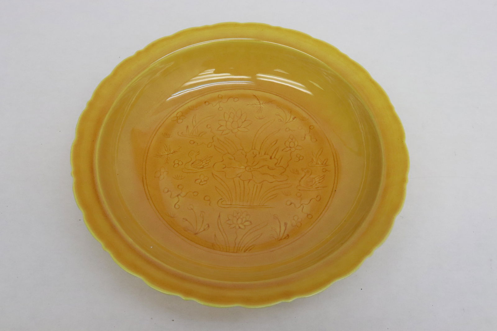 A yellow glazed porcelain plate with incised flowers (1 of 5)