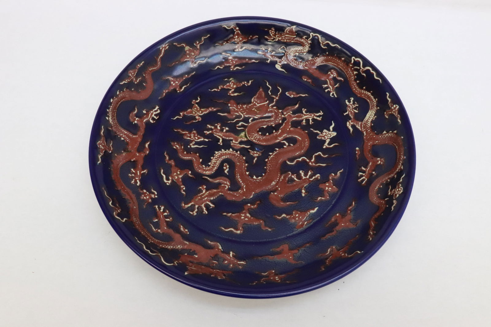 Chinese red on blue porcelain charger: Magnificent Chinese red on blue porcelain charger decorated with dragon at center and border, 2.7"x17.3"dia