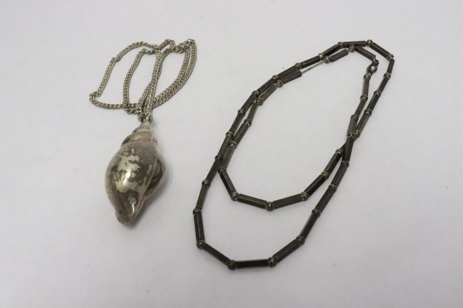 2 sterling necklaces: 2 sterling necklaces; one with shell motif pendant, total wt. 70gm
