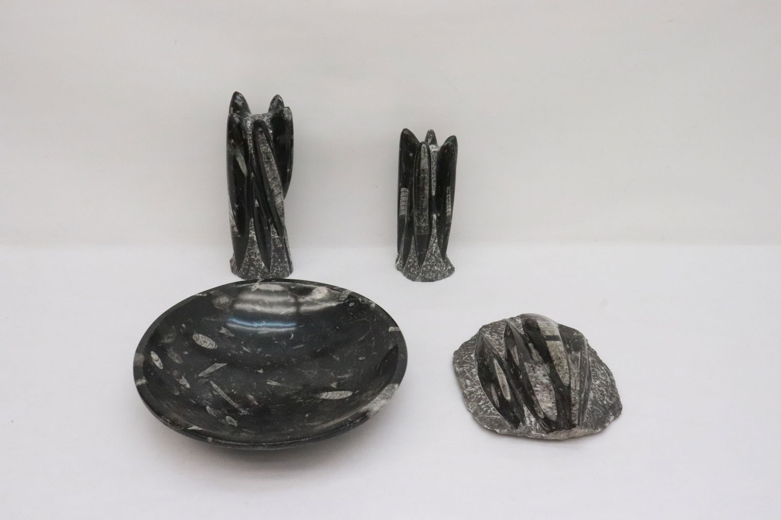 a fossil bowl, a fossil plaque, & pair fossil obelisks: 4 pieces; a fossil bowl (2.5"x9.7"dia), a fossil plaque (7.35"x6.1"x1.85"), and pair fossil obelisks (7.1"H, 8.5"H)