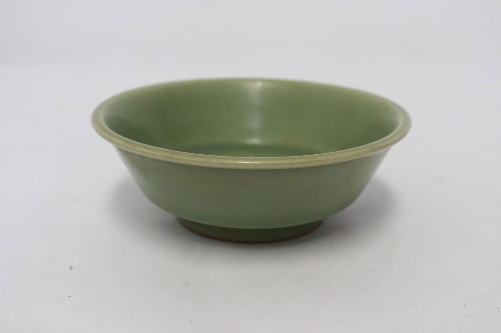 A Ming celadon porcelain bowl: A Ming celadon porcelain bowl with double fish motif decoration in relief, 1.5"x4.25"dia