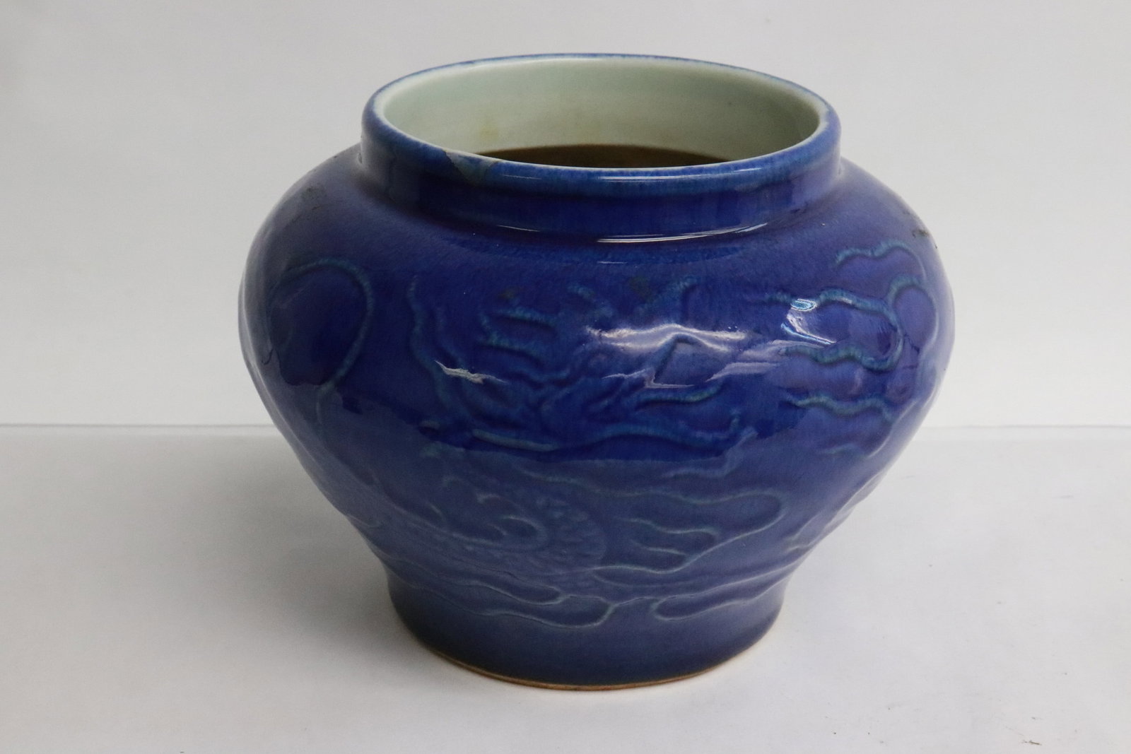 A blue glazed porcelain jar: A blue glazed porcelain jar embossed with dragon motif decoration, 5.1"x6.7"dia