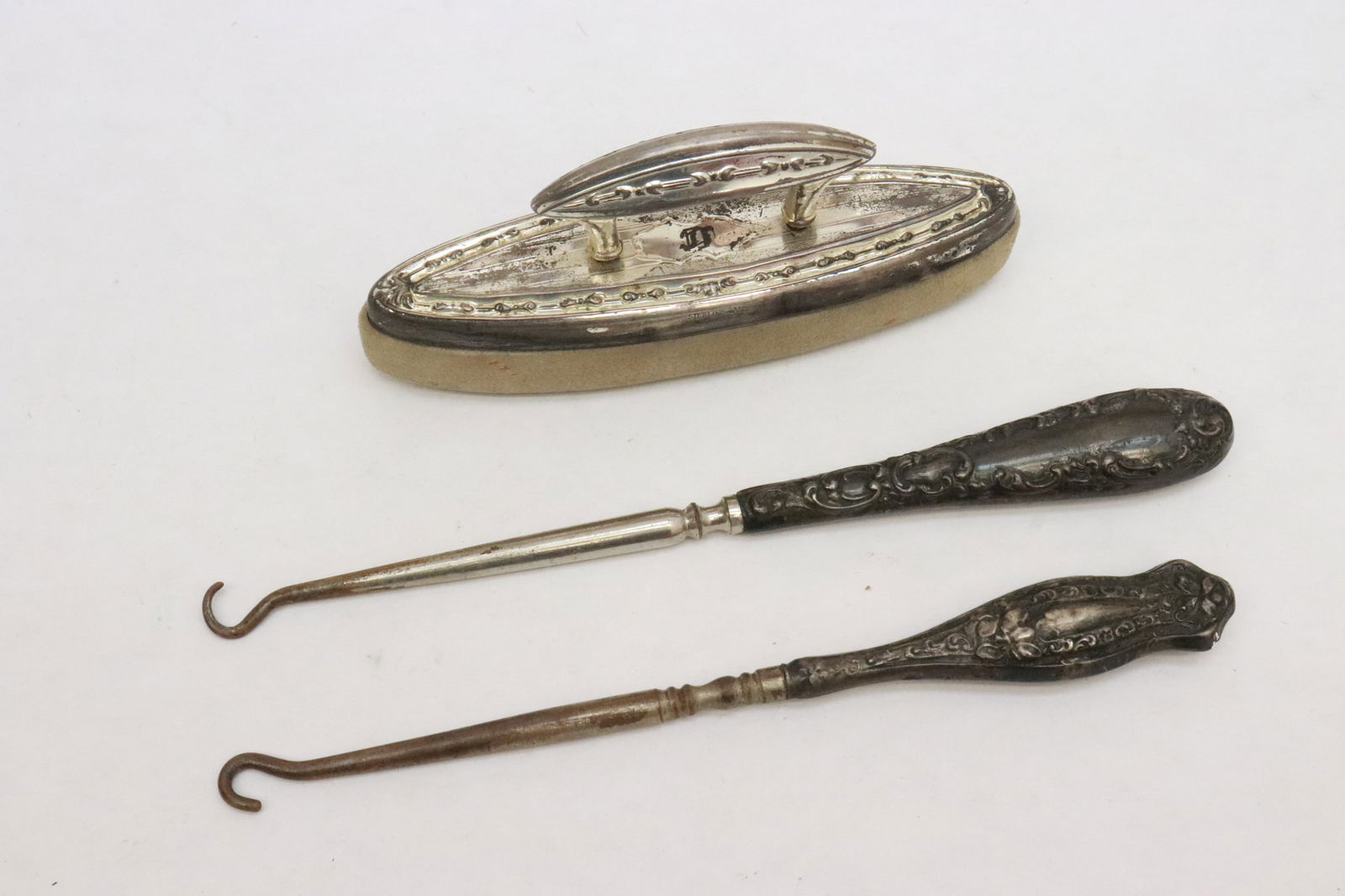 3 sterling pieces: 3 pieces; 2 Victorian sterling handled knitting hooks (6.4"L, 6.85"L), and a Victorian sterling top nail buffer (2.1"x4.65"x1.2")