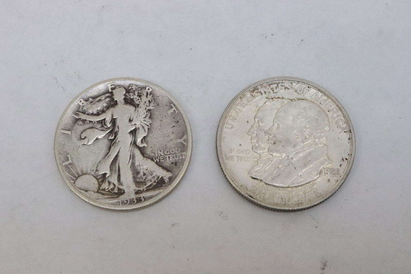 a Monroe and Adams 1923 half dollar, & a 1933 half dollar: 2 silver pieces; a Monroe and Adams 1923 half dollar, and a 1933 half dollar