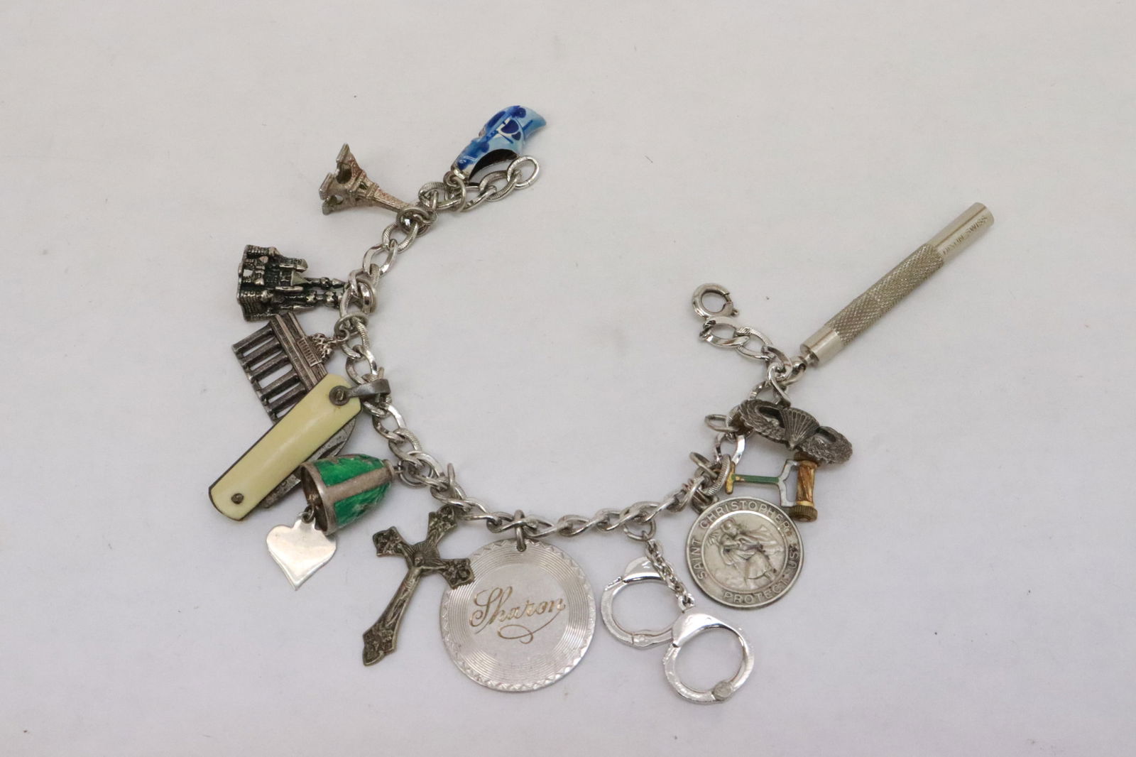 A sterling charm bracelet with 7 sterling charms: A sterling charm bracelet with 7 sterling charms, wt. 46gm, 6.9"L