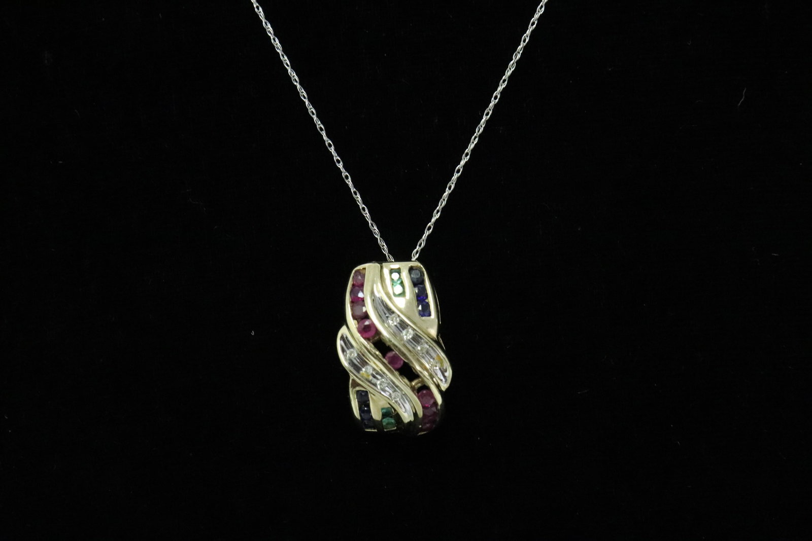 10K pendant with 14K necklace: 10K Y/G pendant (1.8"x0.45") set with ruby, sapphire, emerald, and small diamonds, attached to a 14K W/G necklace, total wt. 4.0gm