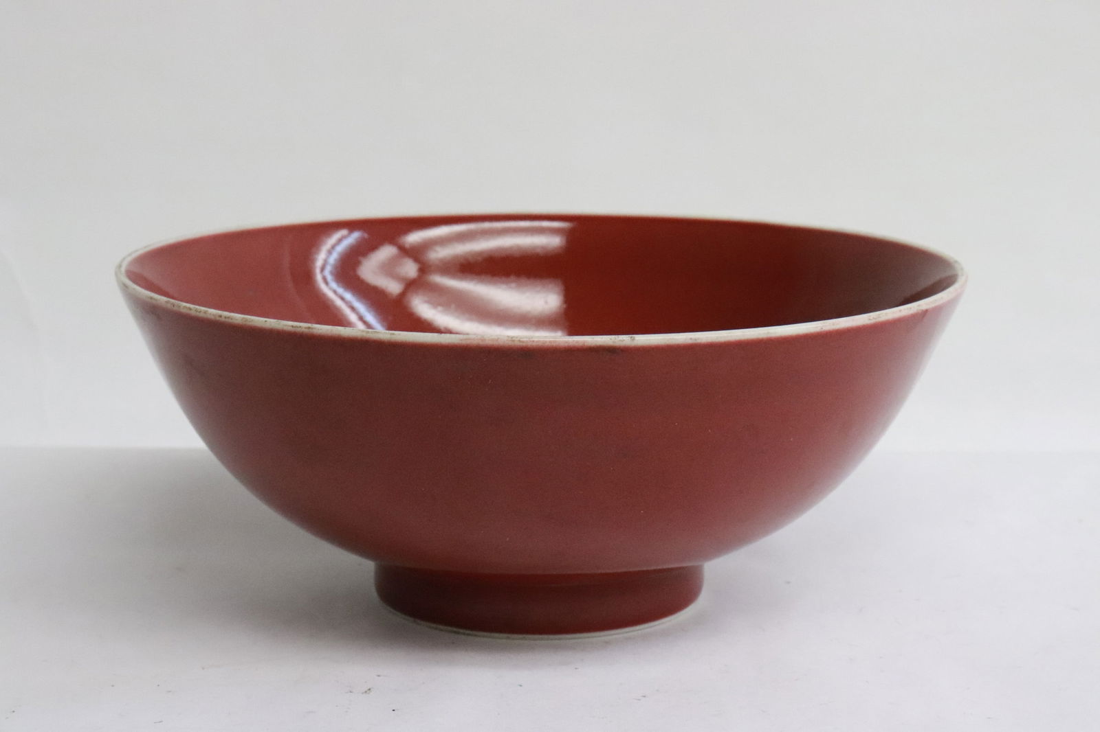 A red glazed porcelain bowl: A red glazed porcelain bowl, 2.65"x6.4"dia