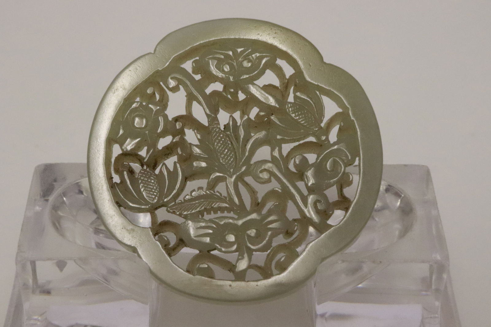 A celadon jade disc in reticulated style: A celadon jade disc in reticulated style, 0.25"x2.3"x2.3"