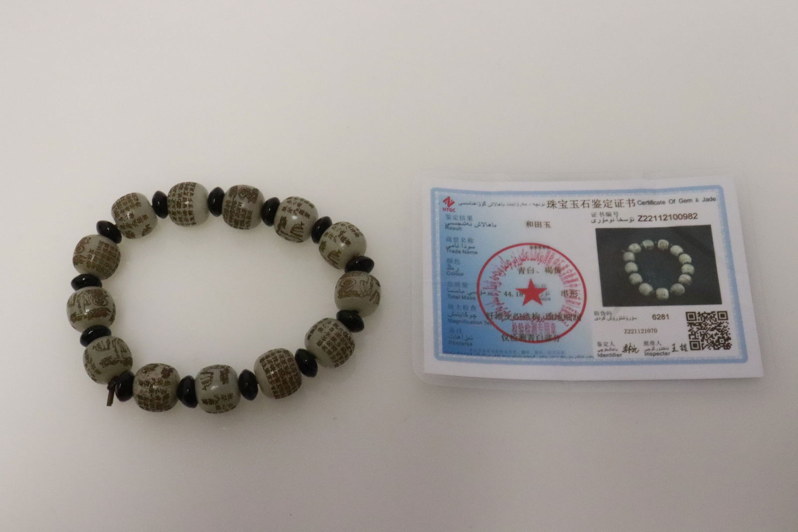 Jade bead bracelet with calligraphy: Jade bead (0.4"x0.5"dia ea) bracelet with calligraphy