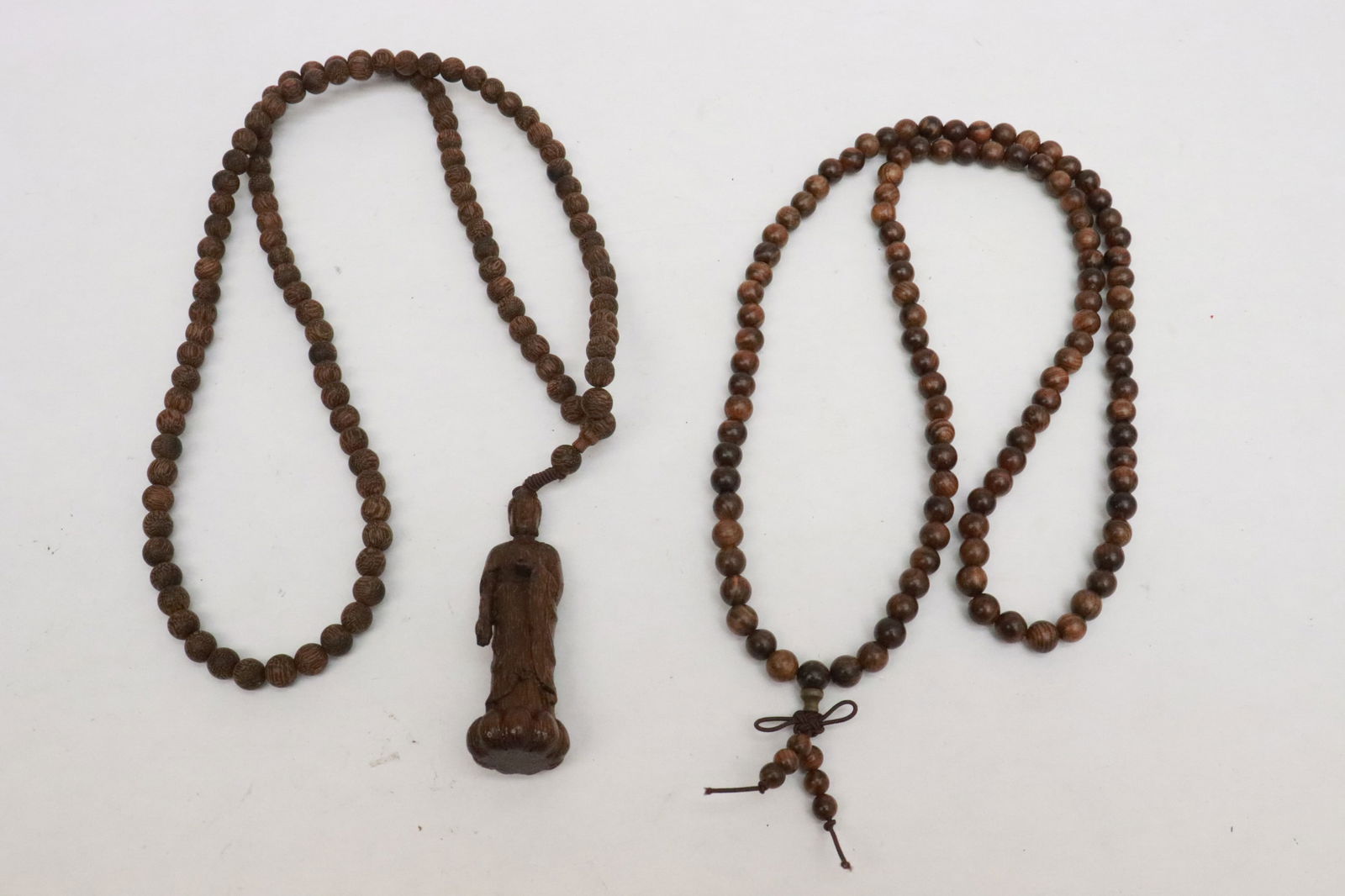 2 wood bead necklaces: 2 wood bead (0.3"x0.3"dia ea) necklaces (34"L); one with deity motif pendant