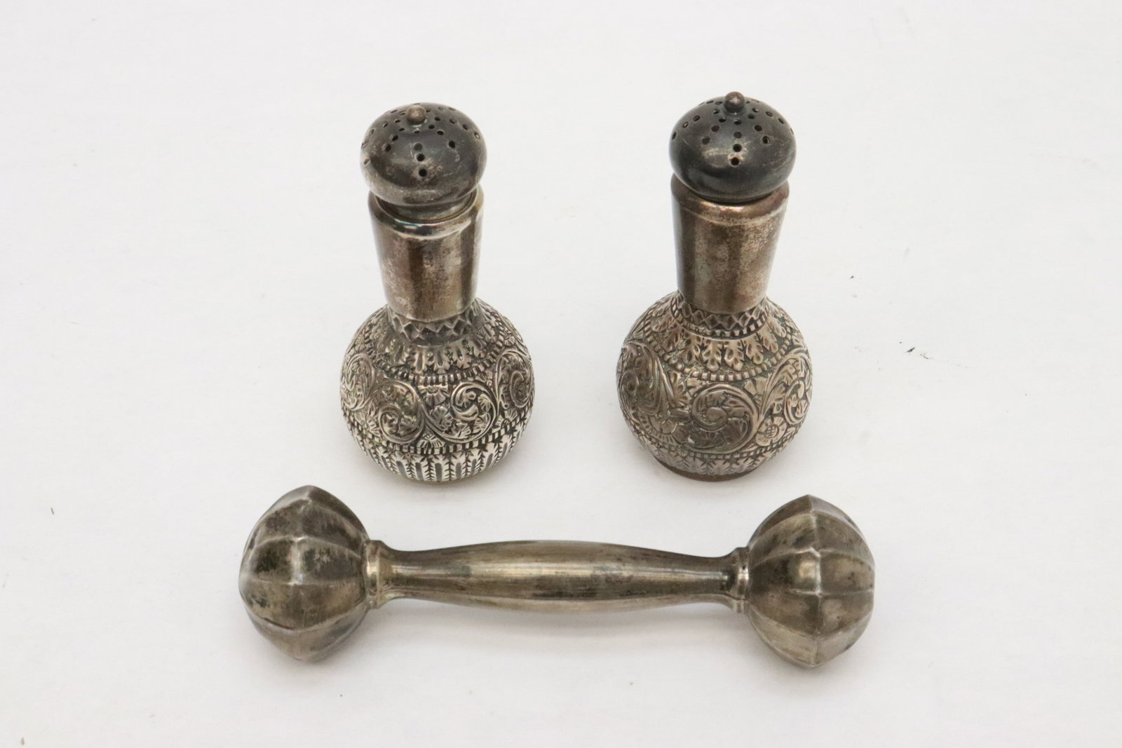 Pair ornate sterling salt and pepper, and a sterling baby rattle, wt. 118gm: Pair ornate sterling salt and pepper (3.2"x1.6"dia ea), and a sterling baby rattle (4.45"x1.25"dia), wt. 118gm