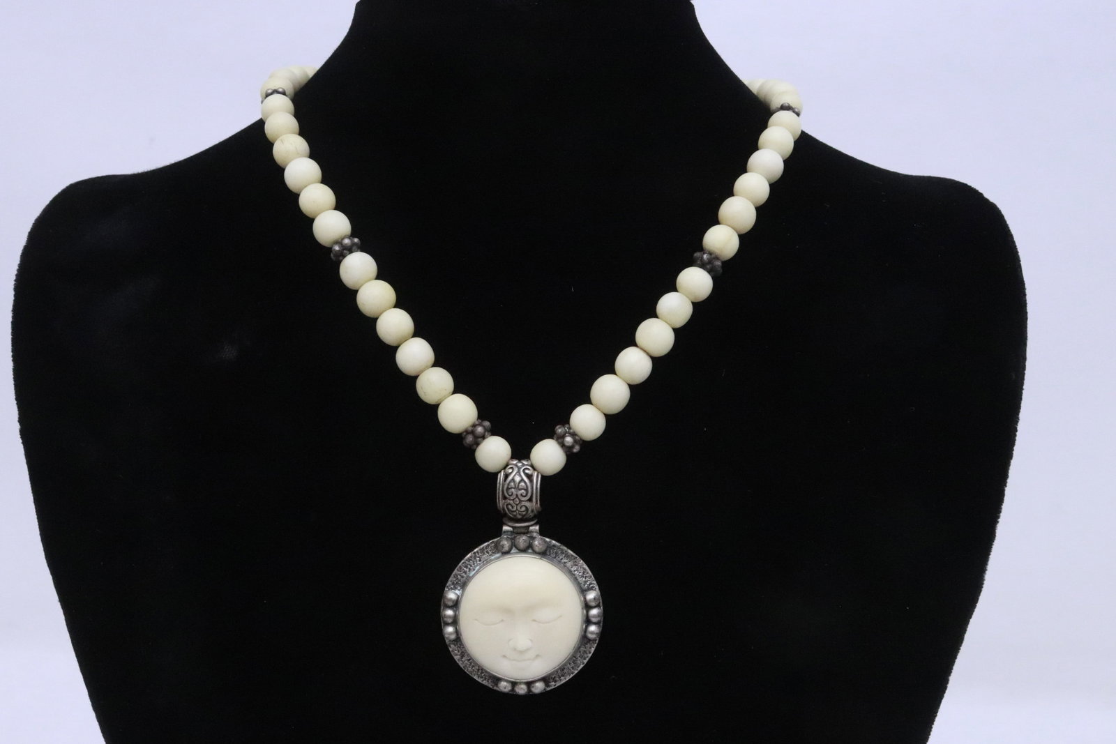 sterling pendant w/ bone and sterling necklace: Very fine sterling pendant (1.8"x1.25"x0.4") with bone carved moon face, attached to a bone and sterling necklace, wt. 52gm (16.5"L)