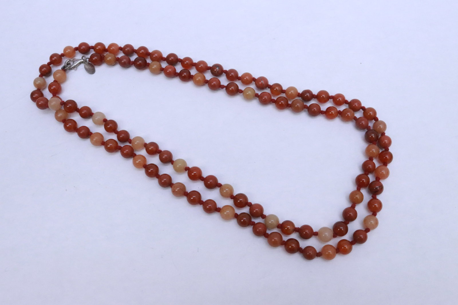 carnelian agate bead necklace w/ sterling clasp: Fine carnelian agate bead (0.33"x0.33"dia ea) necklace (40"L) with sterling clasp, bead measures approx. 8mm diameter