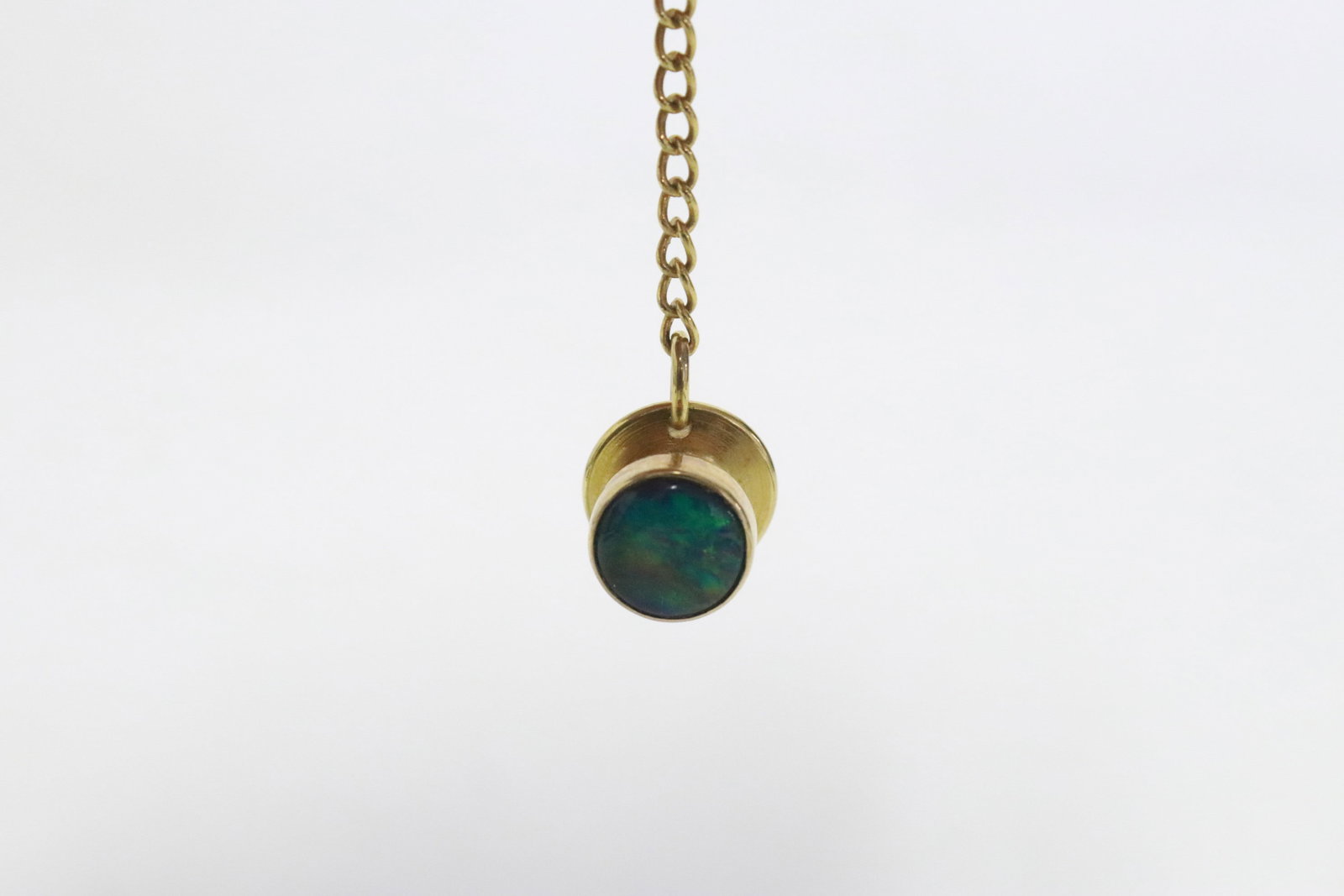 A 10K Y/G tie tack with black opal like stone: A 10K Y/G tie tack (2"L) with black opal like stone, wt. 0.8gm (weight does not include the back)
