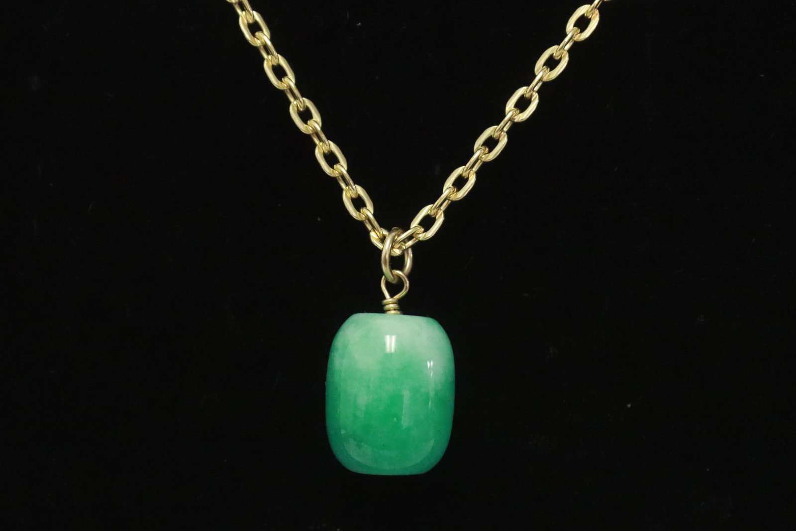 A green jade bead pendant w/ a gold filled necklace: A green jade bead pendant (0.67"x0.6"dia) attached to a gold filled necklace
