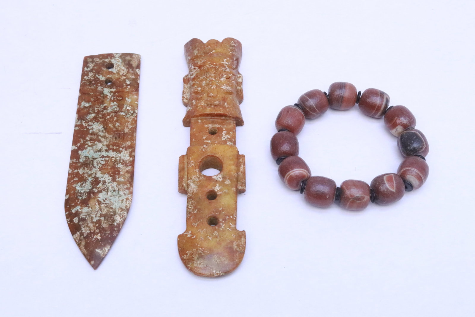 2 stone ornaments, and a bead bracelet: 3 pieces; 2 stone ornaments (5.85"x1.4"x0.2", 6.3"x1.4"x0.65"), and a bead (0.65"x0.63"dia ea) bracelet