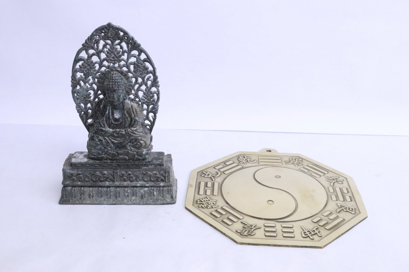 a metal sculpture of deity, and a brass wall hanging (1 of 7)