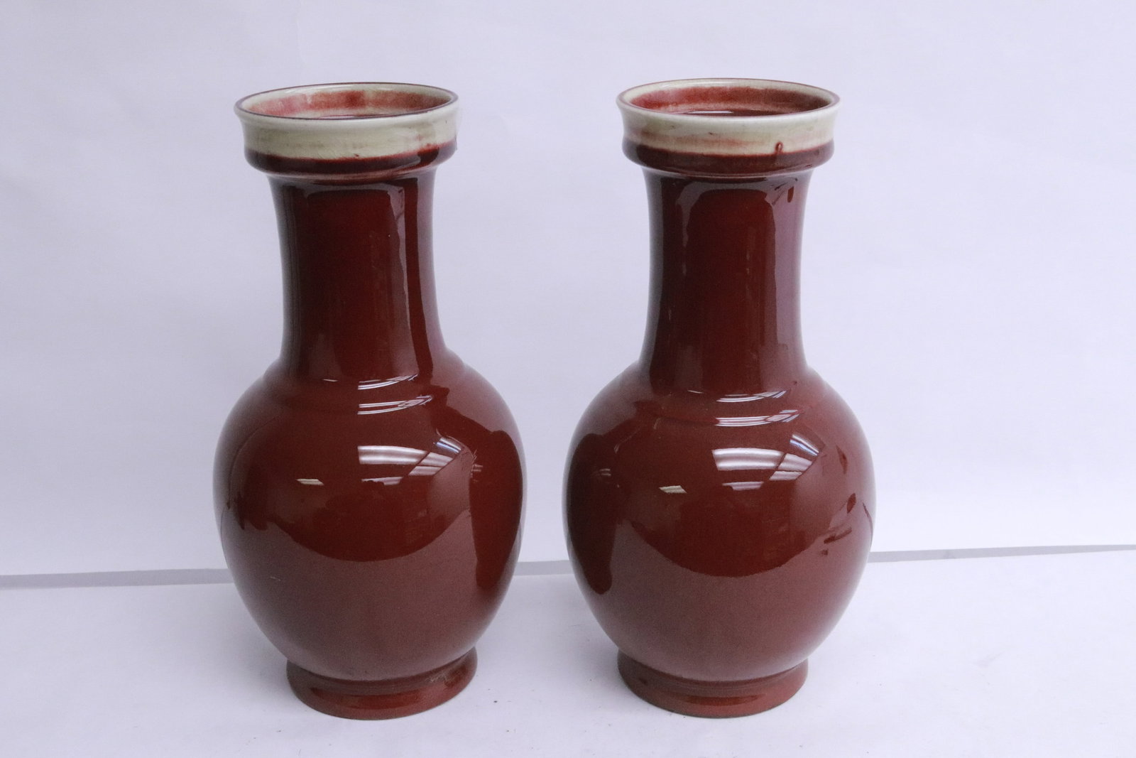 Pair red glazed porcelain vases: Pair red glazed porcelain vases, 9.6"x5"dia ea