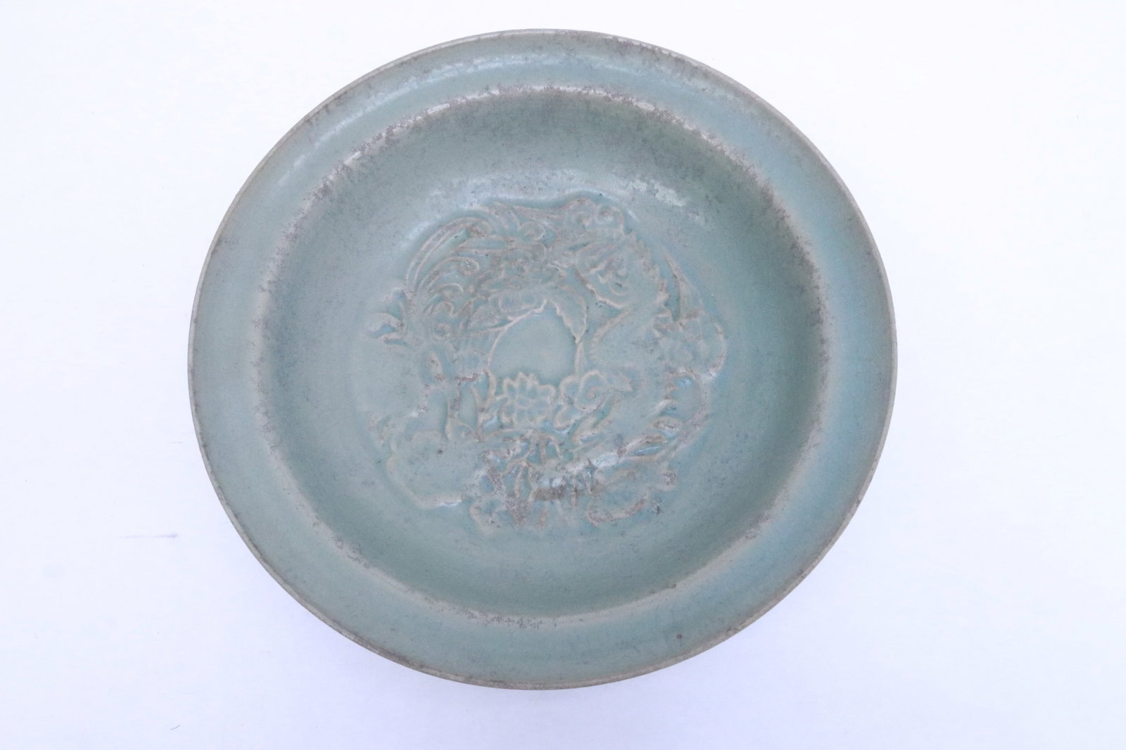 A Song style celadon plate: A Song style celadon plate with phoenix motif decoration in relief, 2.1"x9.1"dia
