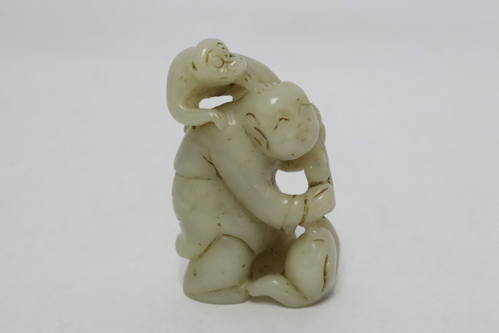 White jade like carving of child with monkey (1 of 6)