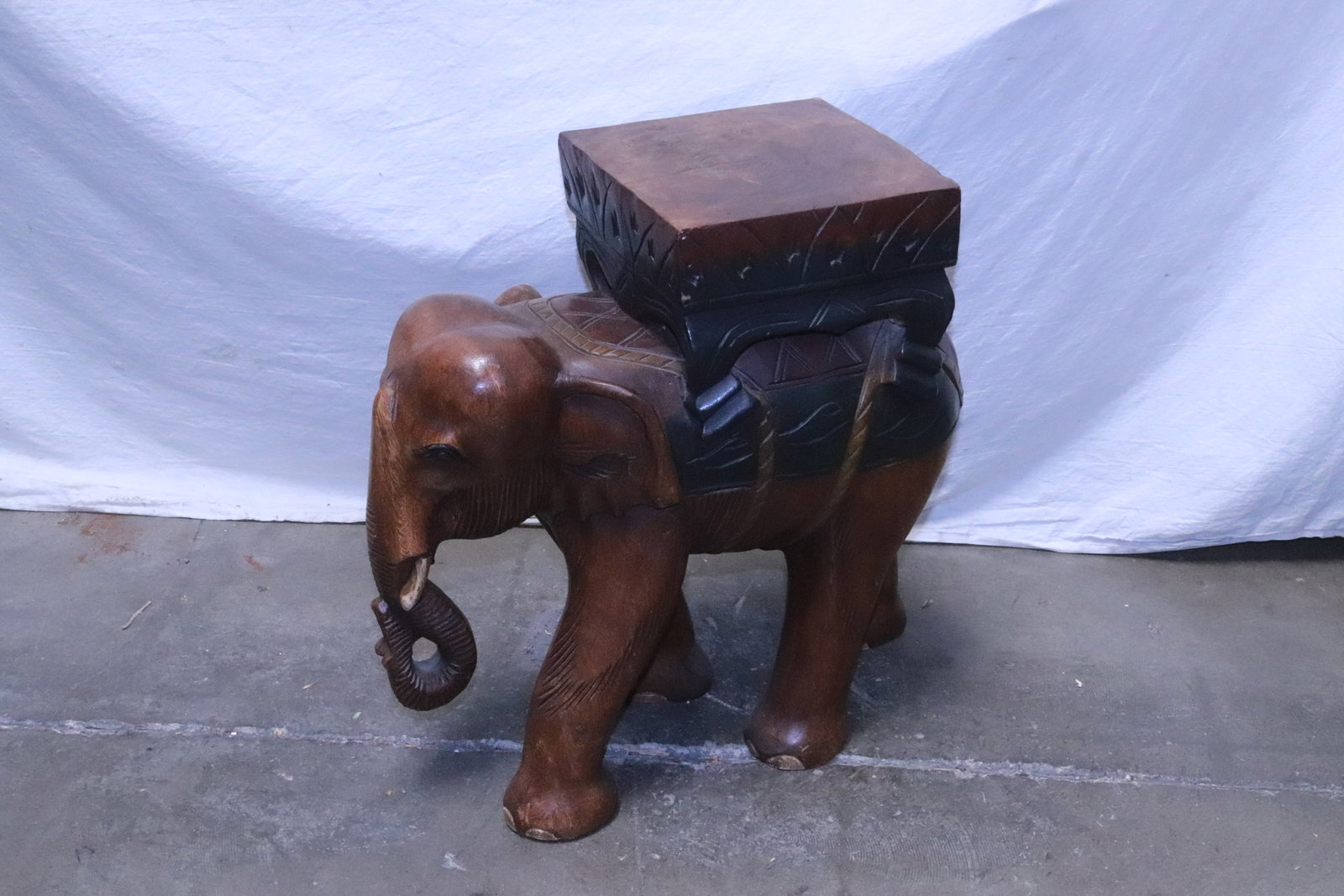 A wood carved stool with elephant motif base: A wood carved stool with elephant motif base, 18.75"x20"x7.7"