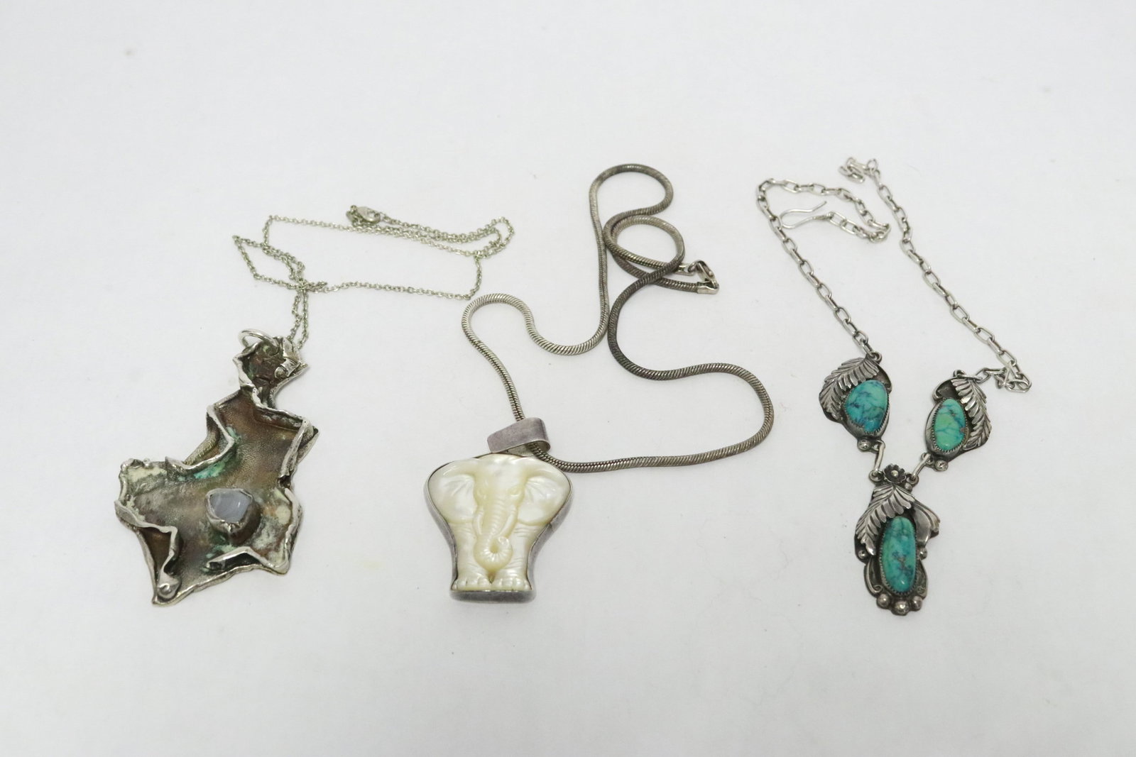 3 sterling pieces: 3 necklaces; sterling necklace (16"L) with turquoise, sterling pendant (1.6"x1.45") with mother of pearl carving in elephant motif, and sterling pendant (3.2"x1.9") signed Jens, total wt. 87gm