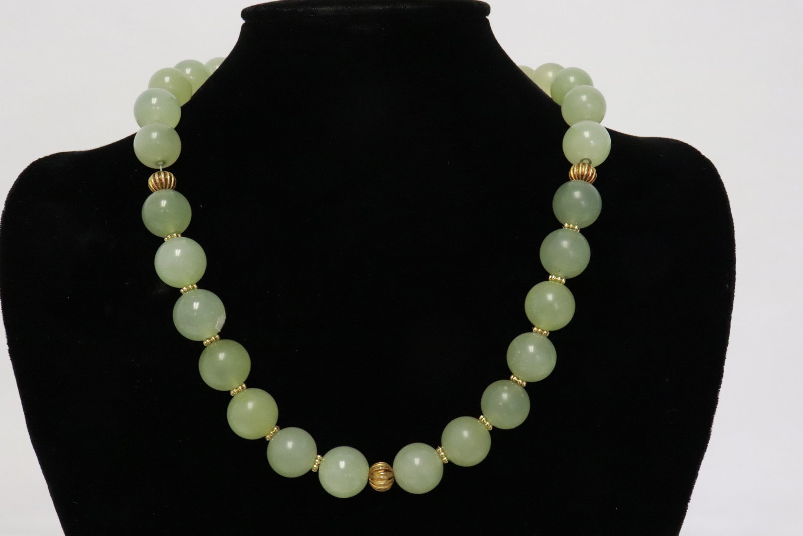 A celadon jade bead necklace: A celadon jade bead (0.6"x0.6"dia ea) necklace (19"L)