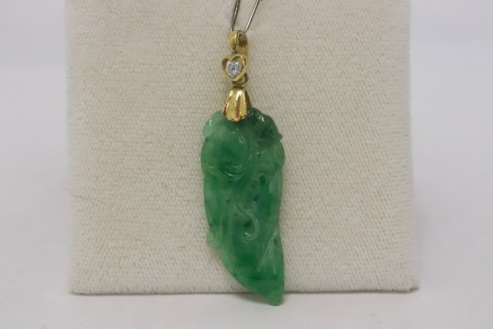 An apple green jadeite pendant: An apple green jadeite pendant (1.35"x0.6"x0.15") with gold filled bale