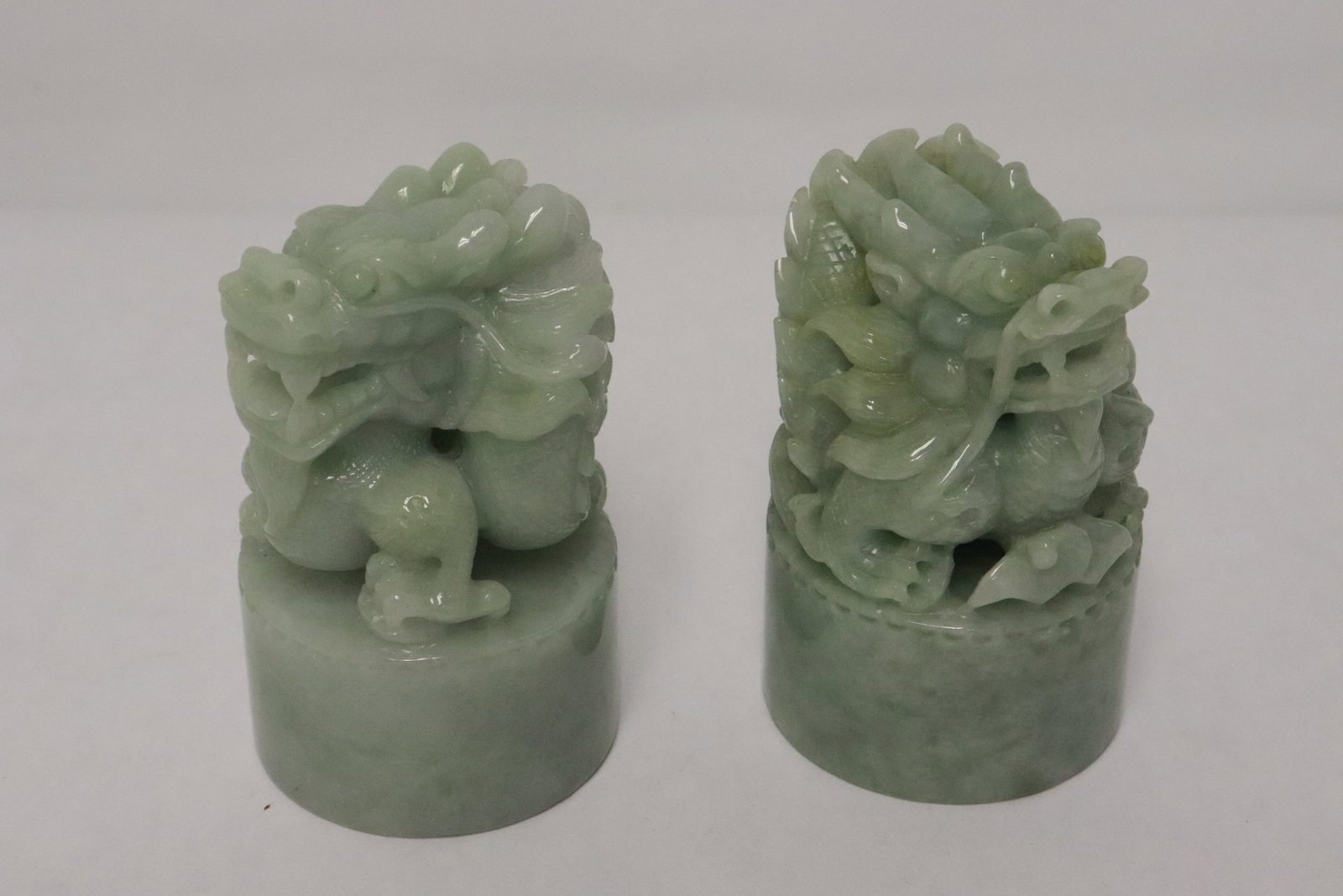 Pair fine jadeite carved seal base: Pair fine jadeite carved seal base with dragon motif finial, 3.35"x2.05"dia ea