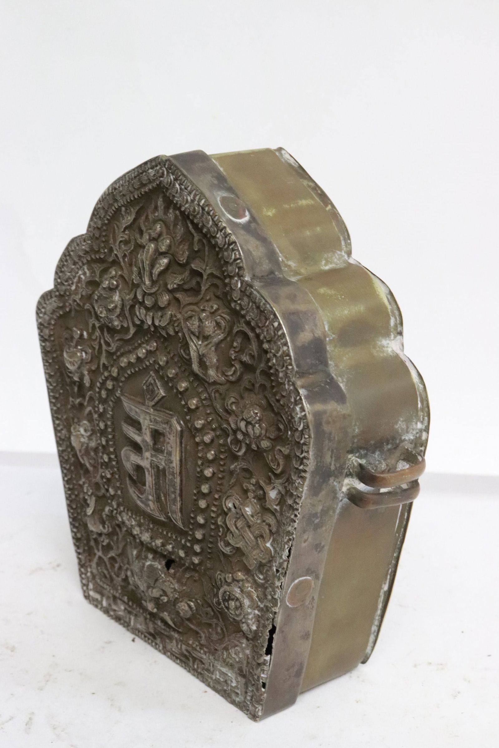 Antique Tibetan metal shrine: Antique Tibetan metal shrine, the top plate tested positive for silver (content unknown), decorated with religious symbols in relief, 5.6"x5.35"x1.85"