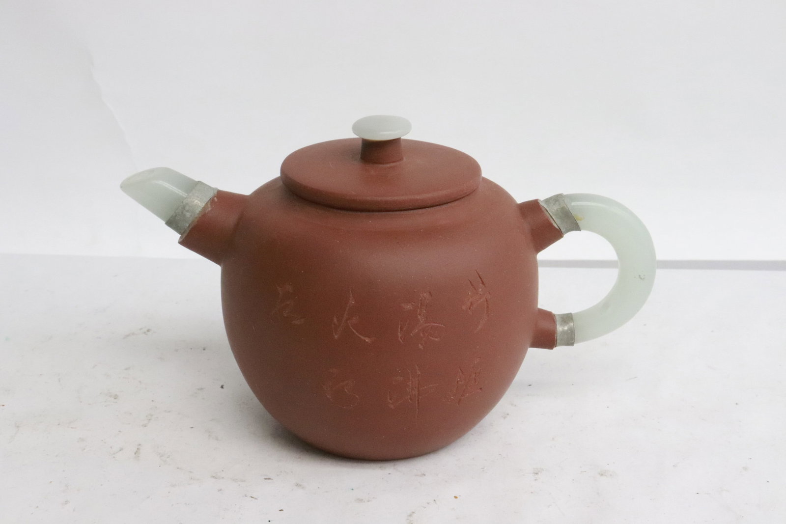 A Yixing teapot with jade like handle and spout: A Yixing teapot with jade like handle and spout, 3.85"x6.2"x3.85"