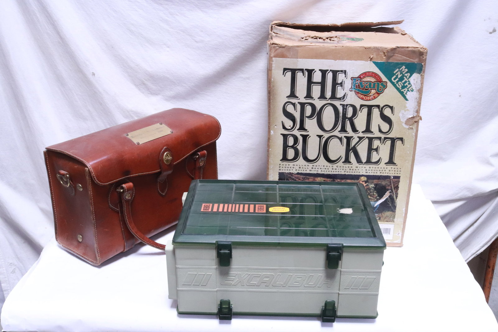 a military stool/ bucket, a leather bag, & a tackle box: 3 items; a military stool/ bucket (17.2"x12.15"dia (box:17.5"x12.2"x12.2")), a leather bag (10"x15.6"x7.6"), and a double sided tackle box (6.6"x15.5"x11")