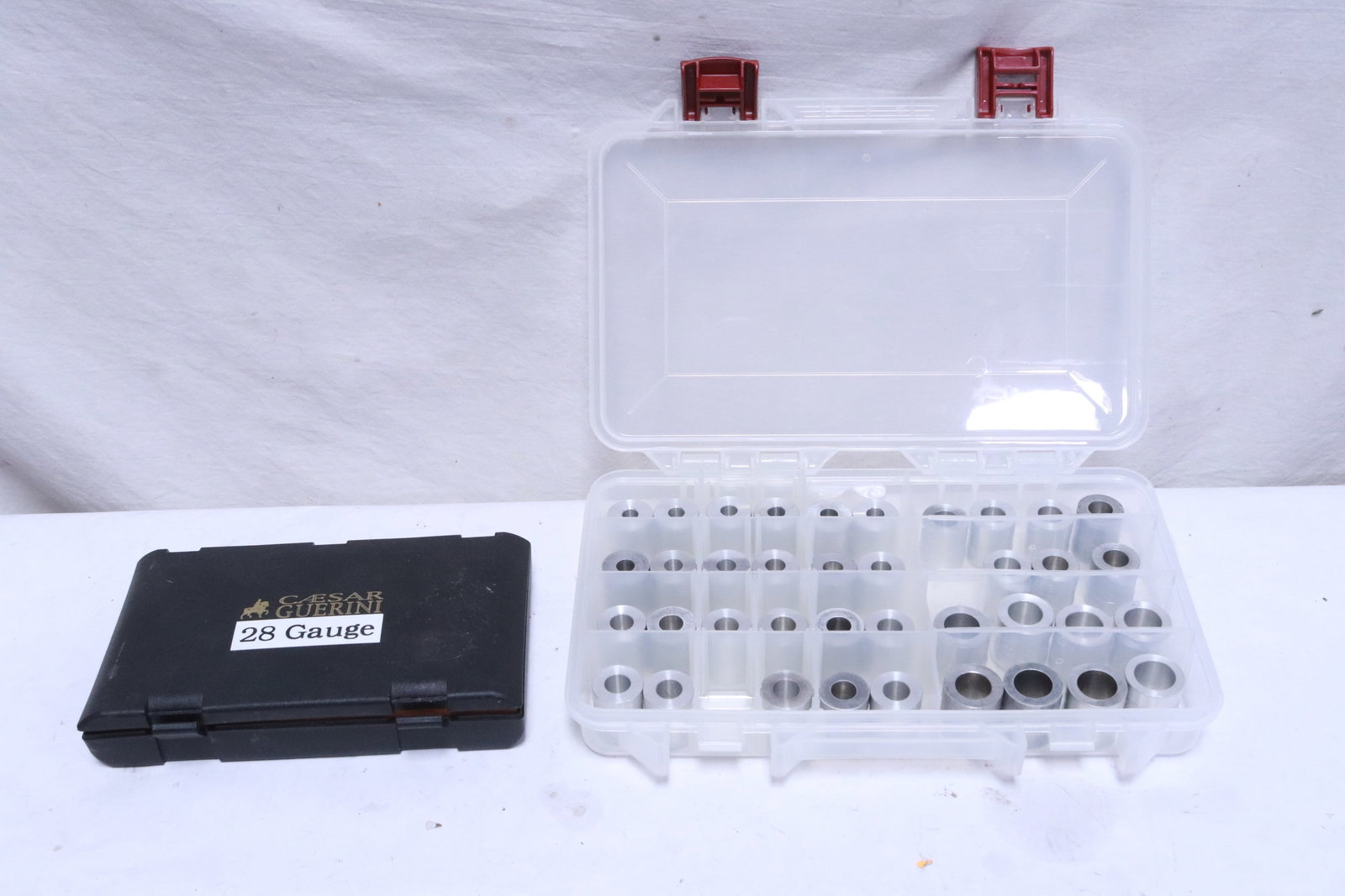 box of reloading bushings, & Caesar Guerini choke case: 2 pieces; box (1.75"x7.3"x10.8") of reloading bushings, a case of Caesar Guerini choke case (4.3"x7.4"x1.2")