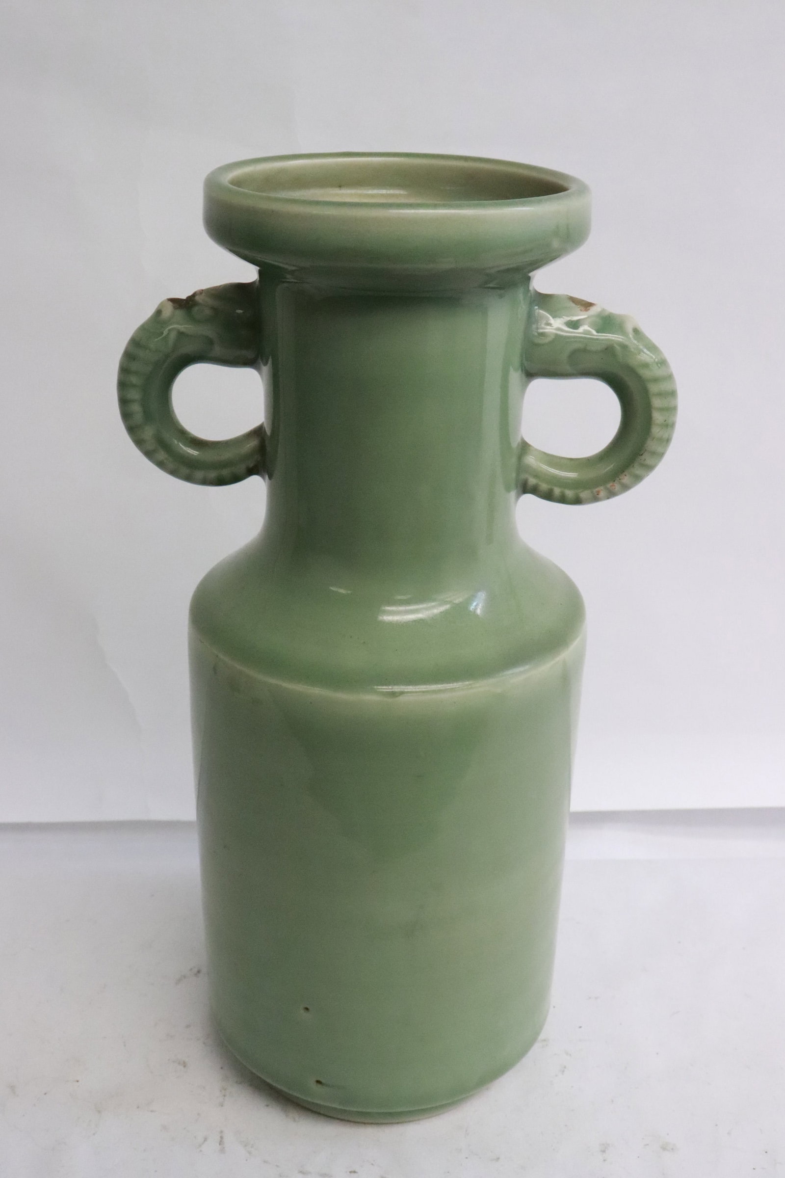 A late Ming celadon porcelain vase: A late Ming celadon porcelain vase with elephant motif handles, 11.15"x6.15"x4.7"