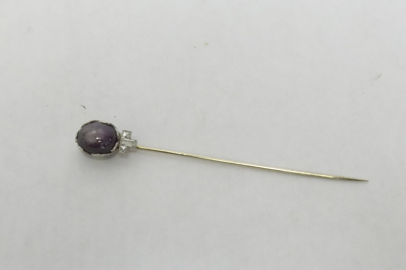 14K stick pin w/ purple star sapphire & diamonds: 14K W/G stick pin (2.85"L) with cabochon purple star sapphire (0.4"x0.3"), accented with 3 baguette diamonds, wt. 2.8gm
