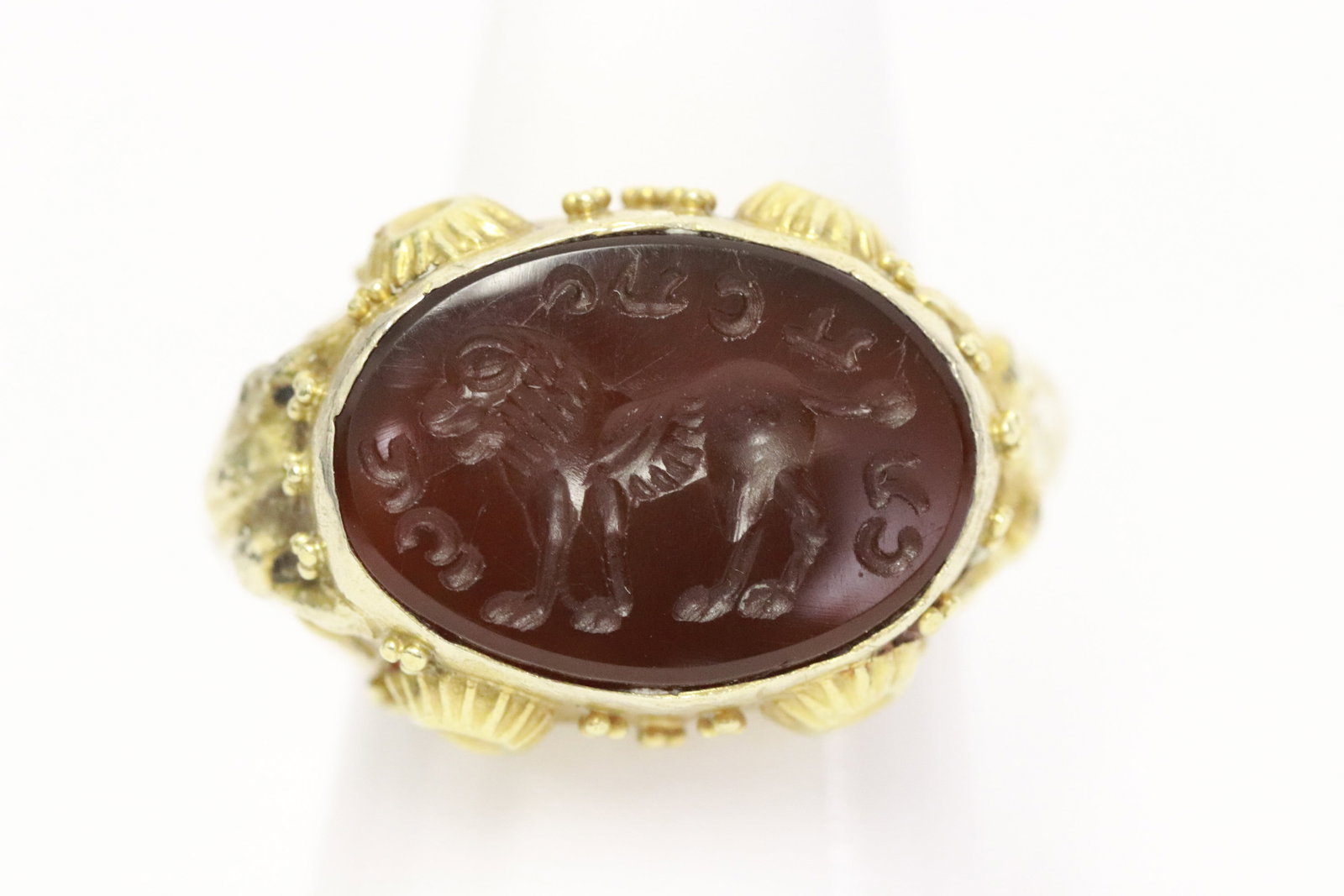 Antique ring: Antique ring, not marked, test about 10-12K, with bull head motif decoration on each side, and set with carved intaglio to depict lion motif decoration, and with ancient symbols, wt. 7.22gm, size 8