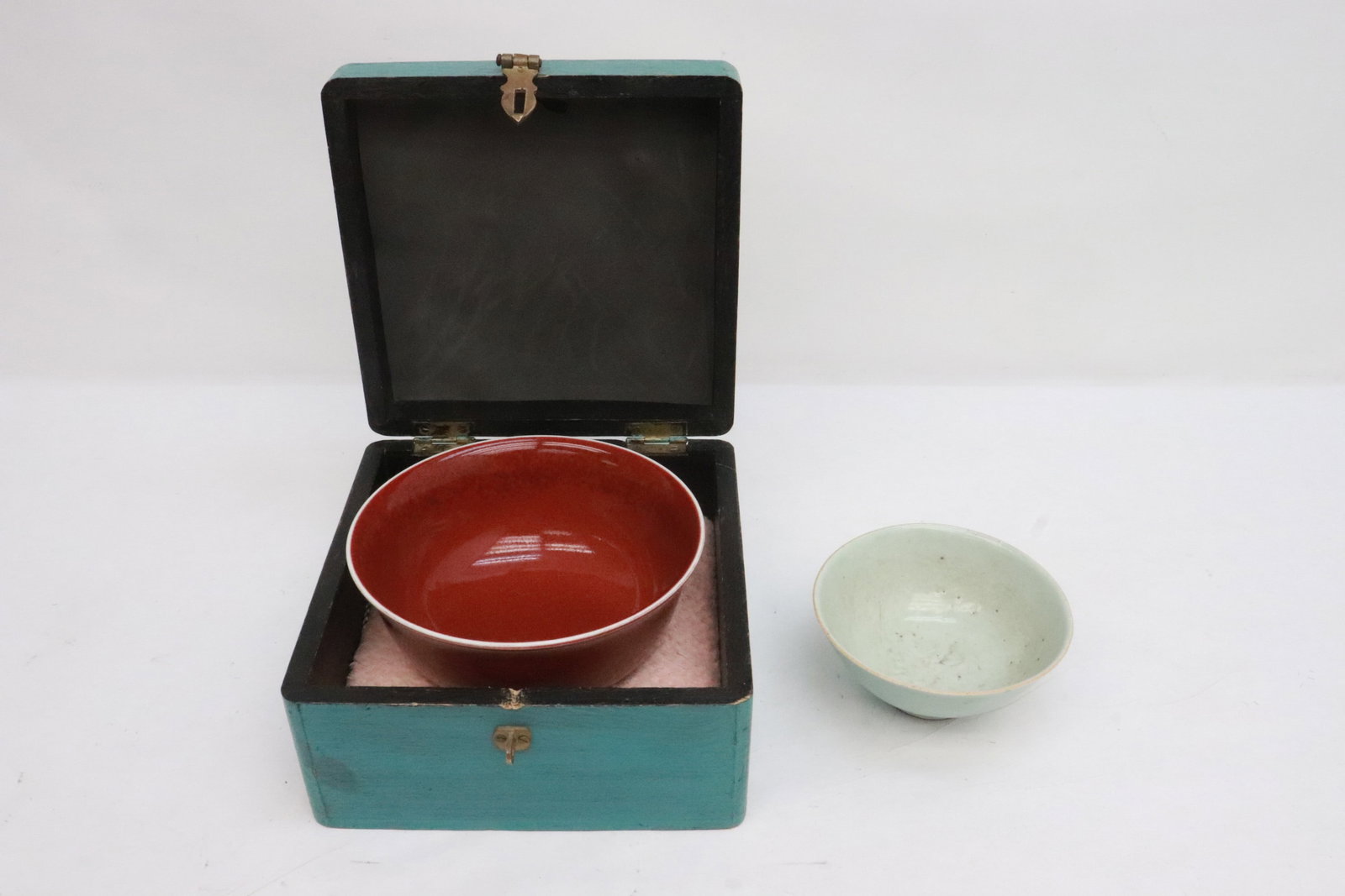 2 porcelain pieces: 2 pieces; vintage Chinese porcelain celadon bowl (2.5"x5.4"dia), and a red glazed porcelain bowl (3.7"x7.18"dia)