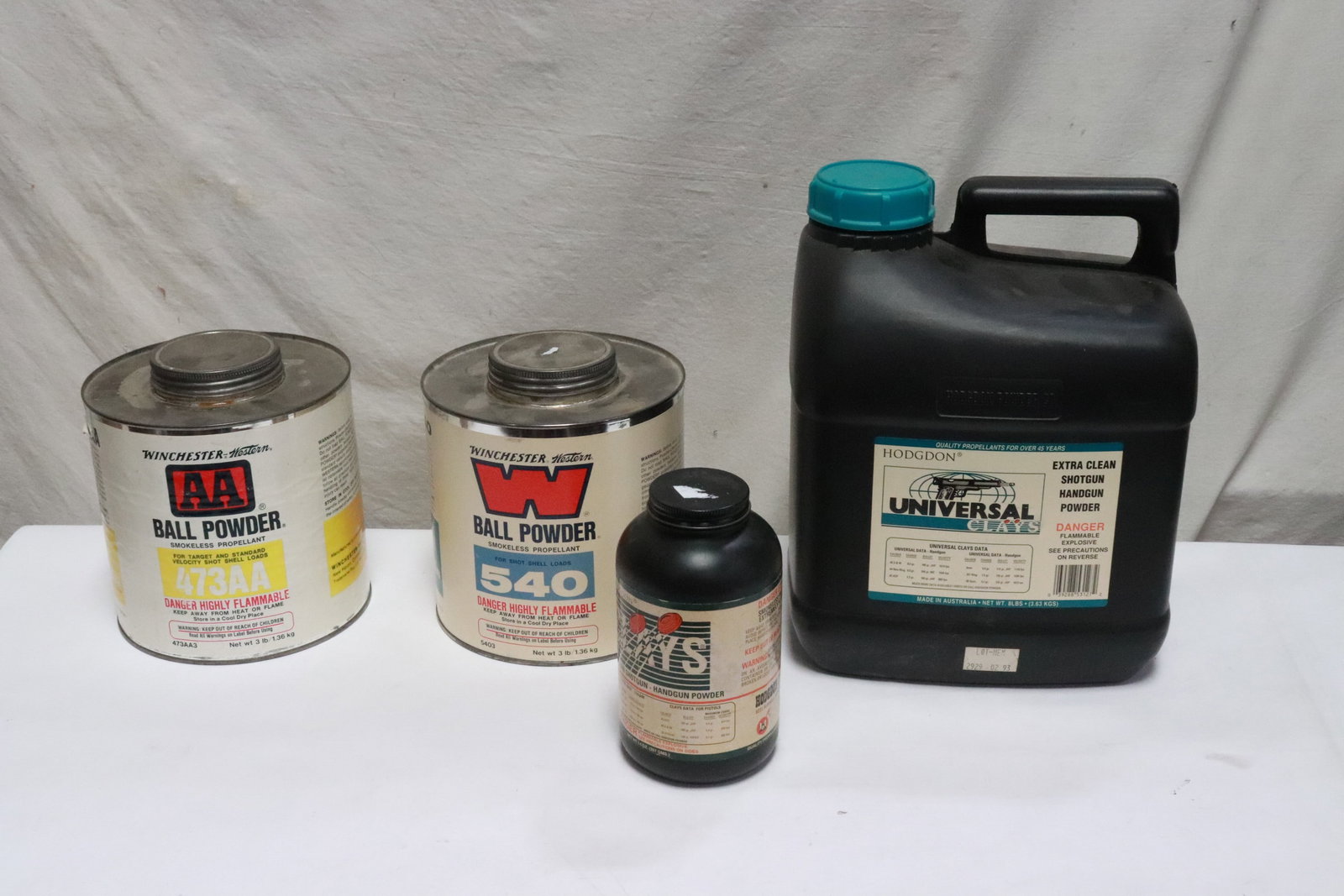 4 bottles: 4 bottles; one 3 lbs Winchester AA ball powder (NIB), one 3 lbs Winchester ball powder (1/4 full), one Hodgdon 8 lbs universal shotgun/ handgun powder (half full), and a Hodgdon 14oz shotgun/handgun p