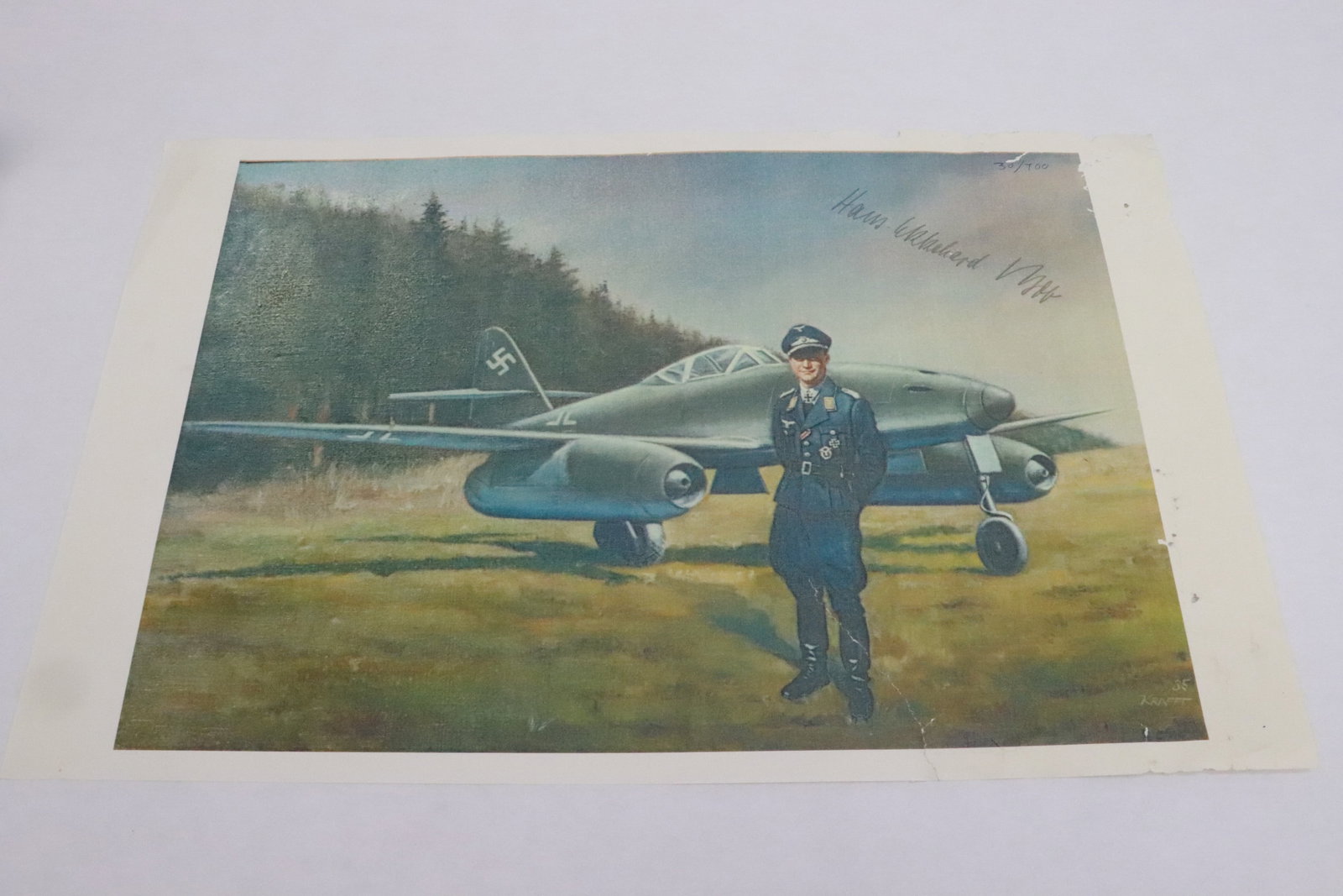 A limited edition print depicting Major Hans Ekkehard Bob: A limited edition print (30/700) depicting German WWII Major Hans Ekkehard Bob standing in front of a jet fighter, repair, 10.8"x17.15"
