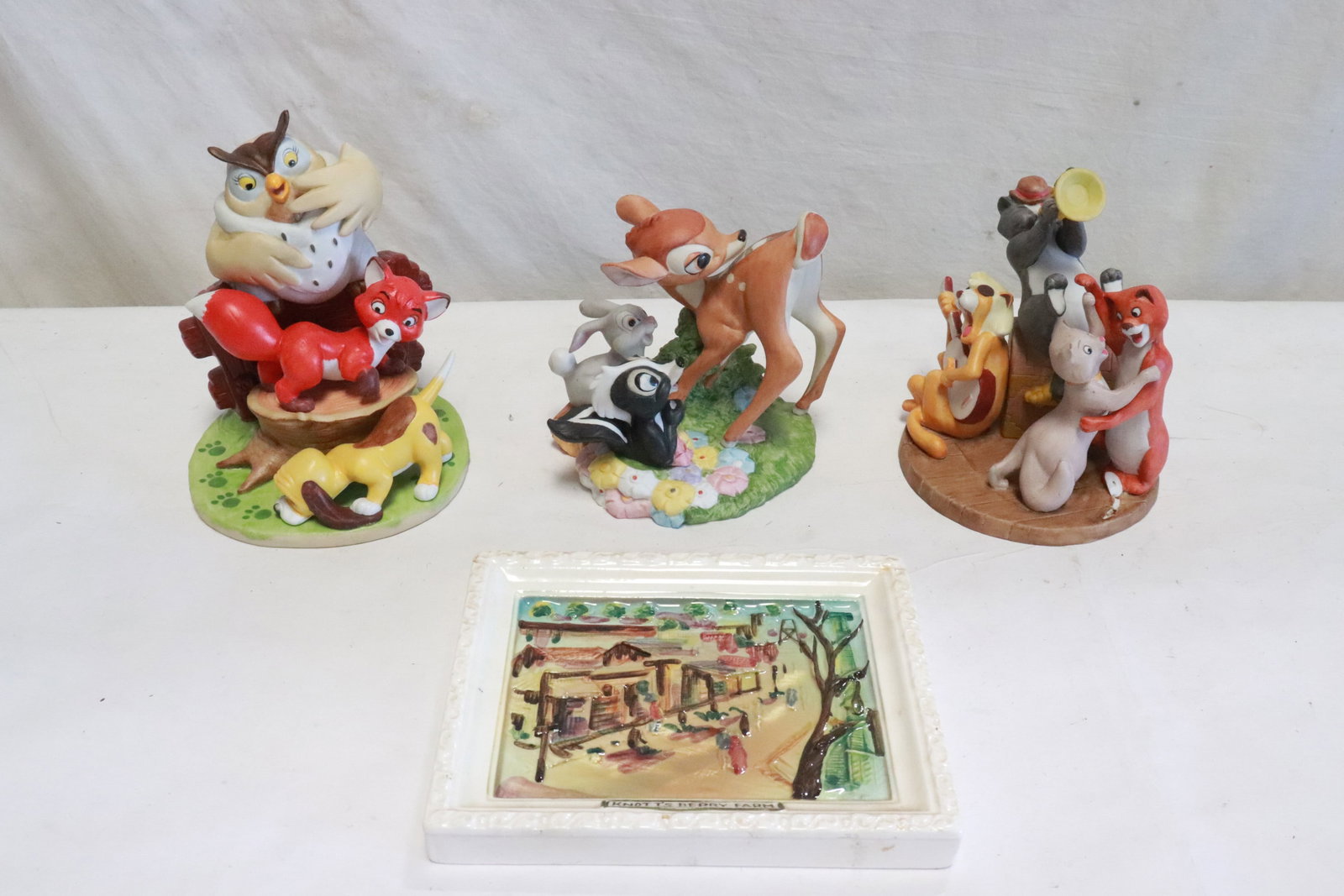 4 items: 3 limited edition Disney porcelain figure groups (bambi tail chip) (6.2"H, 5"H(2)), and a Knotts Berry farm porcelain plaque (5.7"x6.65"x0.7")