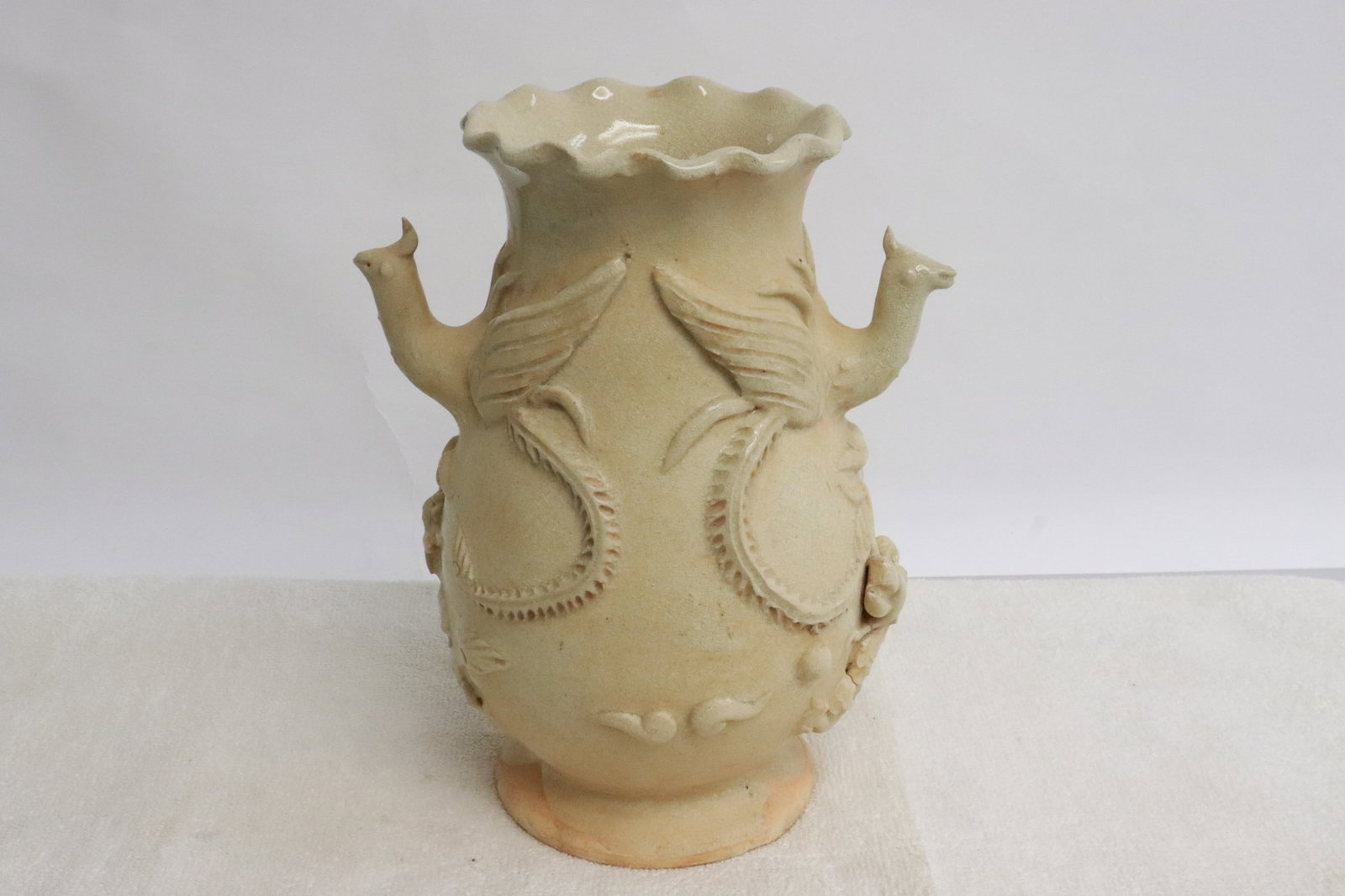 A white glazed porcelain vase: A white glazed porcelain vase with phoenix motif handles, 8"x6.3"x4.85"