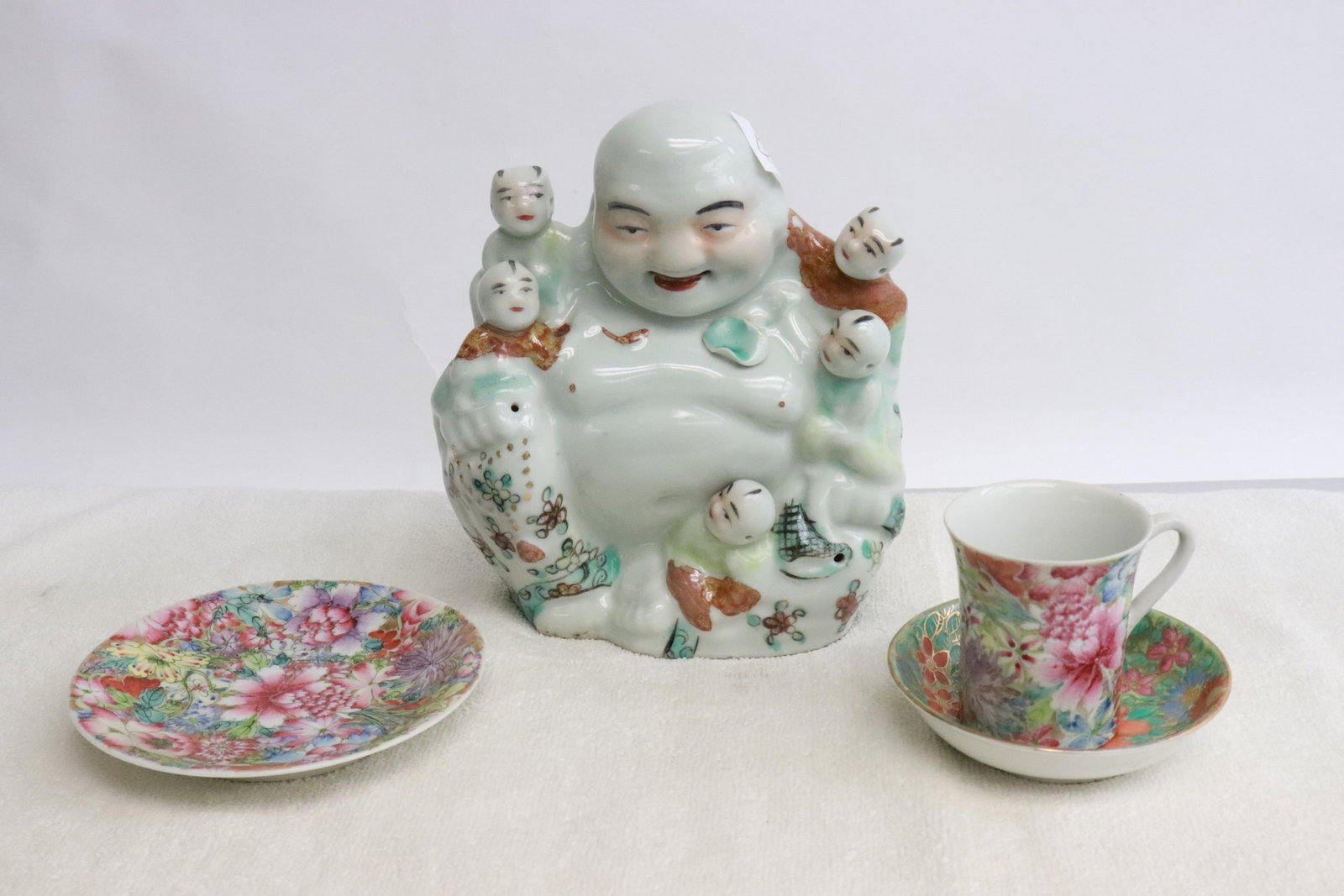 3 porcelain cup and plates, & a wucai porcelain deity: 4 pieces; 3 famille rose porcelain cup (2.63"x3.05"dia) and plates (1.15"x4"dia, 0.85"x5"dia), and a wucai porcelain deity (7.35"H)